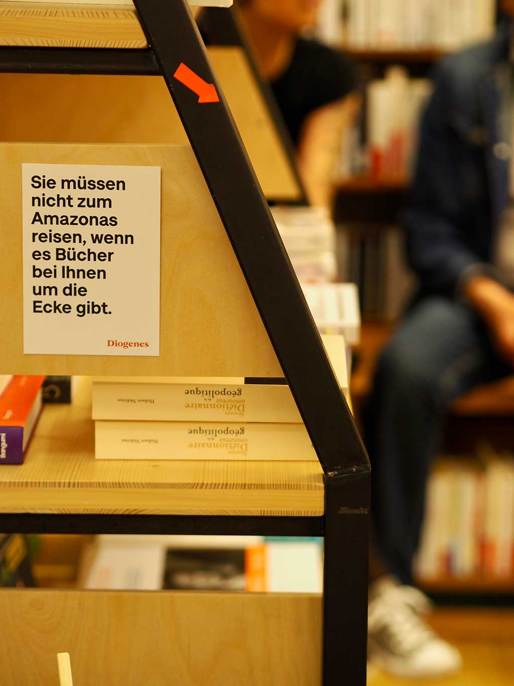 Aufsteller mit dem Spruch „Sie müssen nicht zum Amazonas reisen, wenn es Bücher bei Ihnen um die Ecke gibt“